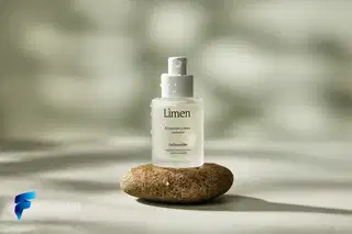 Reve Remix - Foto de produto: sérum "Lúmen" em pedra molhada, luz suave da manhã