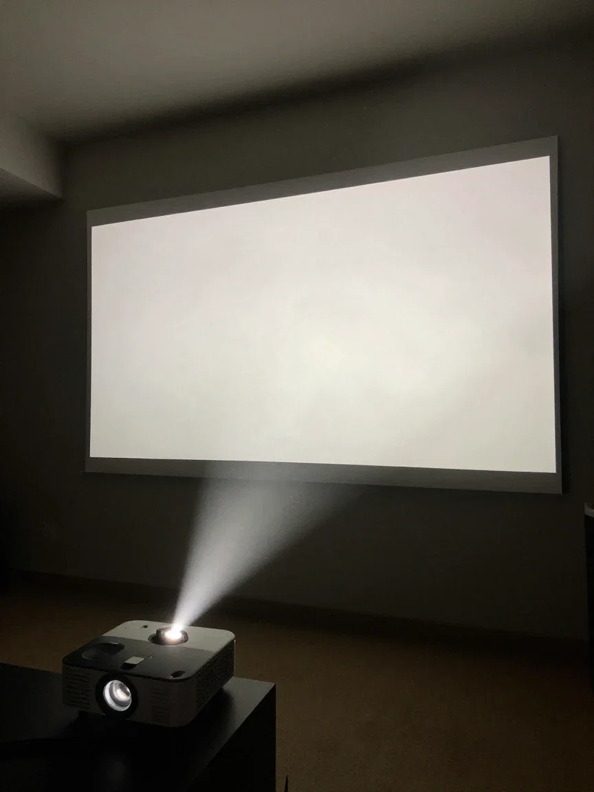 Home cinema projector beam cutting through darkness toward a glowing screen, generated on FluxoKit