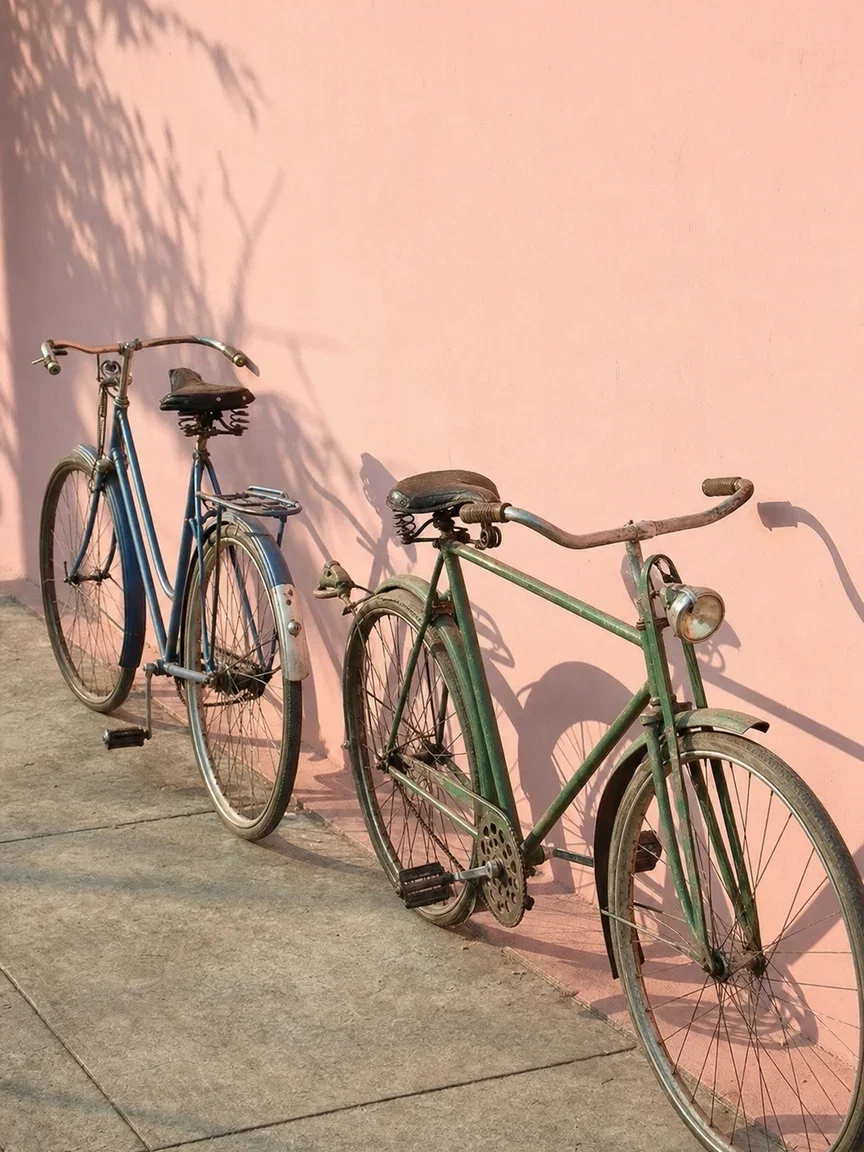 Two vintage bicycles on a pastel pink wall in afternoon sun, generated with GPT Image 2 on FluxoKit