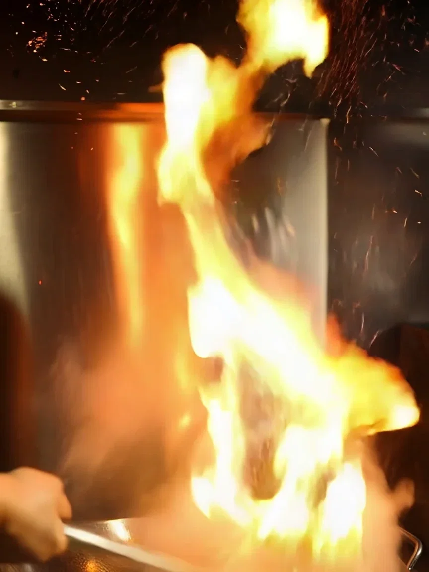 Embers rising through wok steam, beat frame from a Kling 2.6 clip on FluxoKit