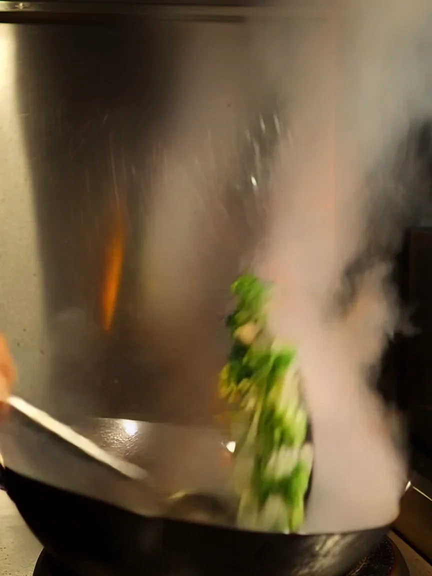 Steam drifting across the wok station pass light, beat frame from a Kling 2.6 clip on FluxoKit