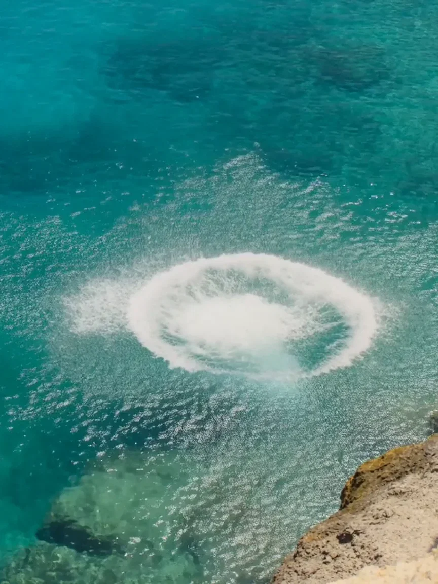 Splash ring spreading across the turquoise cove, beat frame from a Seedance 2.0 clip on FluxoKit