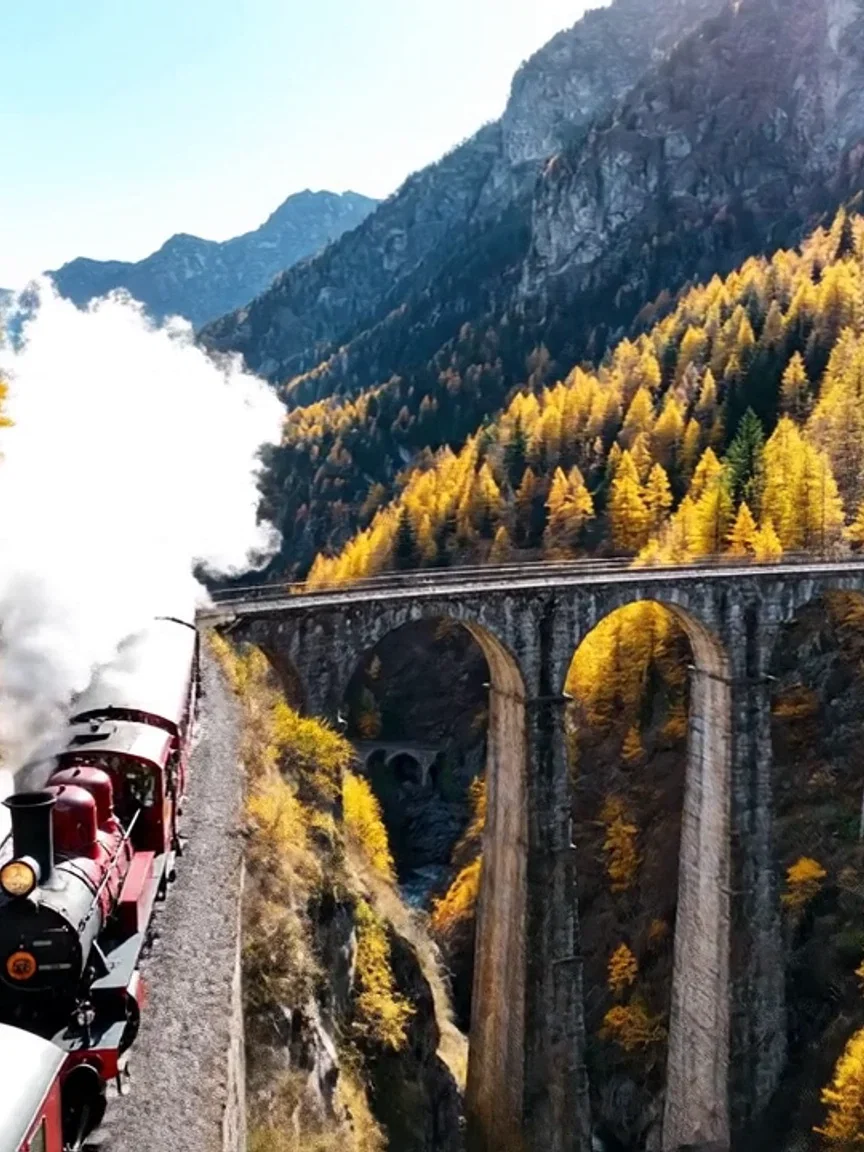 Steam trailing over autumn larches, beat frame from a Veo 3.1 clip on FluxoKit